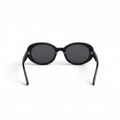 Gafas de sol negras de montura ovalada de EVIE EYEWEAR con lentes oscuras y detalle de logo en la patilla.