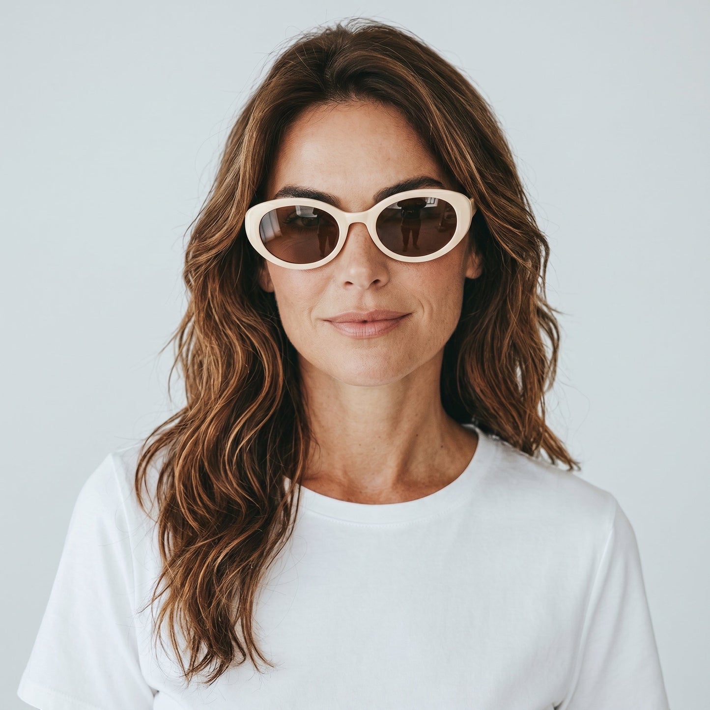 Gafas de sol ovaladas TULUM de EVIE EYEWEAR en color crema con lentes marrones y detalle del logo en la patilla.